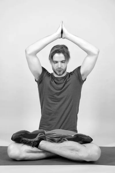 Sportsman relax in lotus pose. Man meditate on yoga mat. Fashion athlete practice yoga in gym. Meditation for body and mind health. Meditation or zen and peace concept