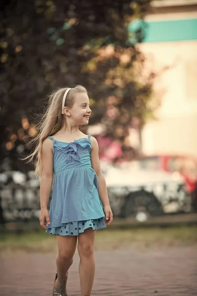 Liten flicka med leende ansikte i blå klänning utomhus — Stockfoto