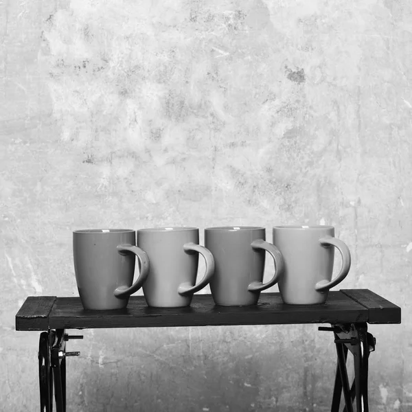 Mesa baixa moderna com tampas de chá ou café perto da parede. Escritório acolhedor e conceito de coffee break . — Fotografia de Stock