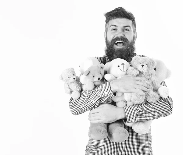 Macho com barba abraça muitos ursos de pelúcia e brinquedos de pelúcia. Presentes e feriados conceito. Homem com cara feliz segura pilha — Fotografia de Stock