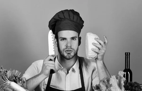 Cook fungerar i köket med grönsaker och verktyg. Köksutrustning och matlagning koncept. Kock med allvarliga ansikte håller kål och kniv på blå — Stockfoto