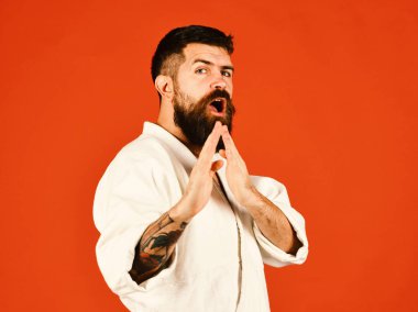Kırmızı zemin üzerine beyaz kimono içinde sakallı adam. Oryantal spor kavram. Taekwondo ana uygulamaları saldırı veya savunma duruş