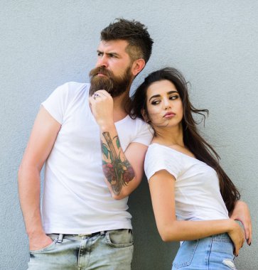 Gençlik şık kıyafet basit ama modern. Hipster acımasız ve şık moda kız takılmak sakallı. Kaç arkadaş birlikte takılmak. Genç ve şık. Çift beyaz gömlek gri duvara yakın kucaklamak