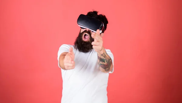 Shooting gallery Vr. Man bebaarde hipster met virtual reality headset op rode achtergrond. Eerste persoonsschutter toont hoe verslavend Vr kon worden. Man handgebaar als gun shooter spel in de Vr-bril — Stockfoto