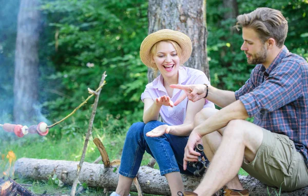 Hand gesture game decide who win. Winner eats first. Couple tourists throwing their gesture while sit log near bonfire. Man and girl play hand gesture game. Couple play rock paper scissors hand game — Stock Photo, Image