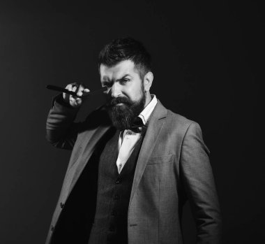 Uzun sakallı adam jileti gözüne yakın tutuyor..