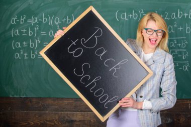 Kadın öğretmen blackboard yazıt okula geri tutar. Öğretmenler yeni öğretim yılı için işe. Seyir öğretmen tamamlayıcı nitelikli işgücü eğitimciler etti. Geri okul öğretmenler işe alım