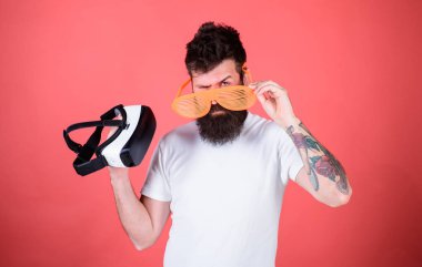 Hangi gözlük louvered veya sanal seçin. Sakallı adam hippi sanal gerçeklik kulaklık ve çok güneş gözlüğü kırmızı arka plan ile. Alternatif gerçeklik. Adam ne tercih gerçek veya sanal karar