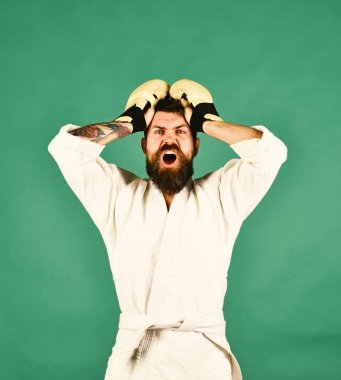 Yeşil arka planda beyaz kimonolu sakallı bir adam.