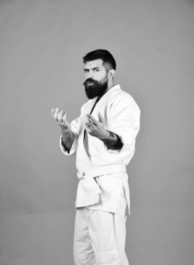 Kırmızı arka planda beyaz kimonolu sakallı adam.