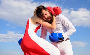 Onun güç ve güç kendine güvenen bir kız. Eşitlik hakları için mücadele. Tam isabet. Kendinizi savunmak nasıl öğrenin. Erkek ve kadın boks eldiveni mavi gökyüzü arka plan mücadele. O kendini savunmak nasıl bilir