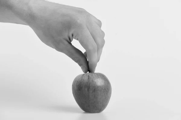 La mano masculina sostiene la manzana roja clara. Manzana sobre fondo claro — Foto de Stock