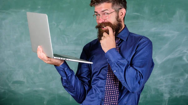 Le piratage scolaire. Hipster professeur porter des lunettes et cravate détient ordinateur portable surfer sur Internet. Professeur barbu rusé homme moderne ordinateur portable surf internet tableau arrière-plan. Informations intéressantes — Photo