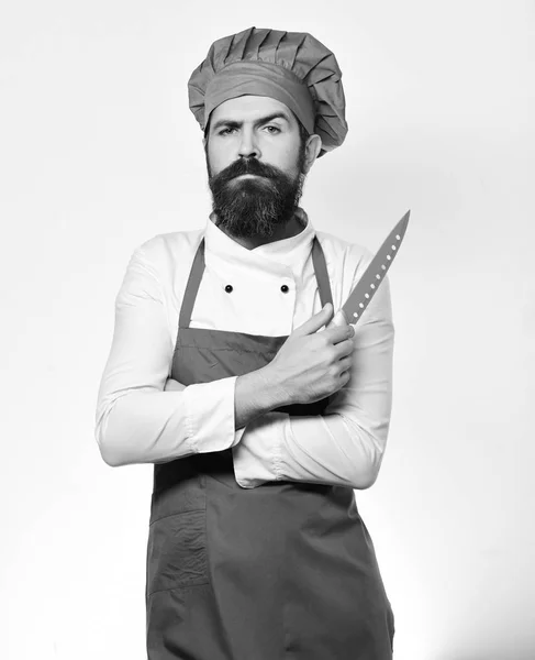 Cocinar con la cara orgullosa en delantal de color burdeos y sombrero de chef. —  Fotos de Stock