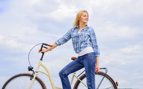 Aktywny wypoczynek i zdrowy aktywności. Dziewczyna jeździć na krążownik modelu roweru. Kobieta jedzie rower na tle nieba. Najzdrowsze najbardziej przyjazny i najbardziej satysfakcjonujące formami własny transport — Zdjęcie stockowe