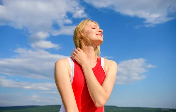 Concepto de coqueta y coqueta. La luz del sol agradable cálido. Mujer vestido rojo se siente despreocupado y libre. Chica rubia sonriendo disfrutar de la luz del sol cálido cielo azul con las nubes de fondo. Chica juguetón estado de ánimo coqueta — Foto de Stock