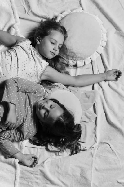 Las colegialas en pijama rosa duermen sobre almohadas coloridas, vista superior —  Fotos de Stock