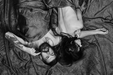 Ağzını gösteren sakallı adam bir bayanla yatıyor.