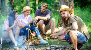 Sosis arkadaşlar paylaşım izlenim ve izlerken fotoğraflar kamera üzerinde konuşma sırasında kavurma hippi. Arkadaş grubu turist şenlik ateşi rahatlatıcı. Atıştırma zamanı olan turistler ile yangın gıda kavrulmuş
