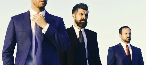 Managers dragen slimme pakken, stropdassen op blauwe lucht achtergrond — Stockfoto