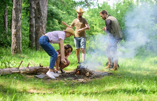 Meg dolgozik, mint a csapat tartani a máglya. Vállalat kemping erdő előkészítése máglya piknik. Adjunk hozzá néhány fa, a tűz. Vállalat barátaival vagy családjával, hogy máglya erdő jellegű háttér — Stock Fotó