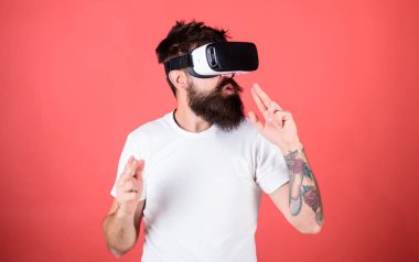 Adam kırmızı zemin üzerine sanal gerçeklik kulaklık ile hippi sakallı. VR oyun çekim. Adam el hareketi olarak silah oyun shooter oyun Vr gözlük. Birinci kişi ateş gösterir nasıl bağımlılık Vr olabilir