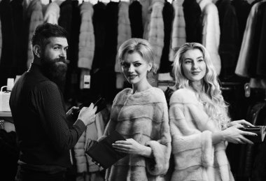 Mor ve pembe kürklü mantolar tezgâhtar ile kadınlarda.