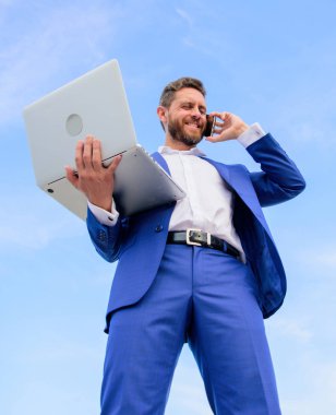 Beceri iletişim. Adam resmi takım modern teknoloji Yöneticisi girişimci cevap telefon görüşmesi. Adam iyi giyimli işadamı dizüstü speak telefon mavi gökyüzü arka planı süre tutar. Her zaman temas halinde