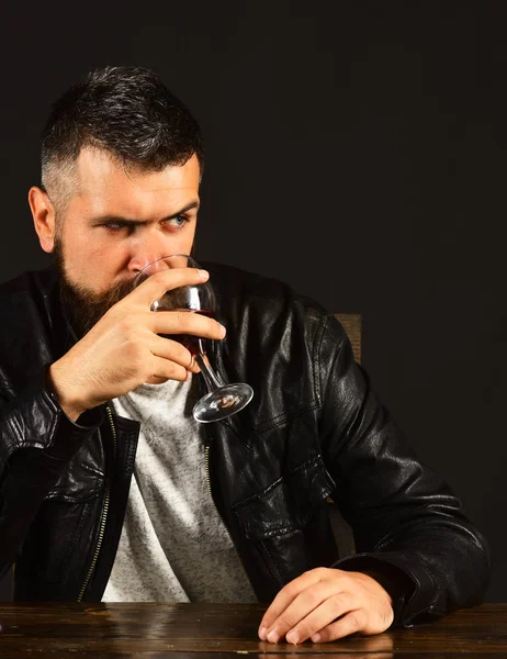 Homem com barba segura copo de vinho no fundo marrom — Fotografia de Stock