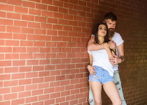 He will never let her go. Couple in love hugs brick wall background. Couple find place to be alone. Girl and hipster romantic date intimacy moment. Couple enjoy intimacy cuddling without witnesses