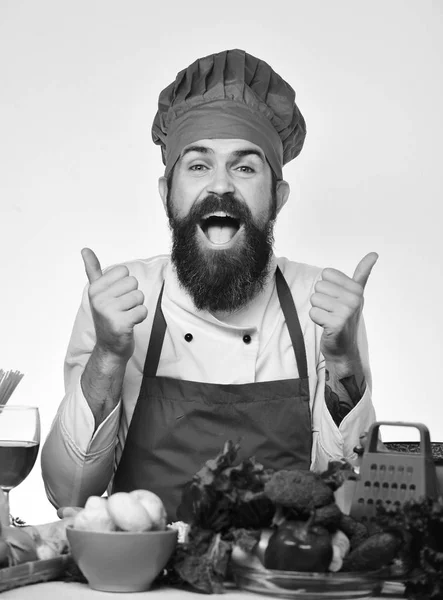 Laga mat med glada ansikte i uniform sitter vid köksbordet — Stockfoto