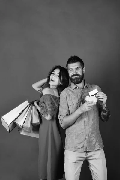 Couple in love holds shopping bags on green background.