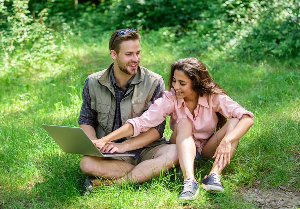 Couple youth spend leisure outdoors with laptop. Modern technologies give opportunity to be online and work in any environment conditions. Man and girl looking at laptop screen. Nature best workspace