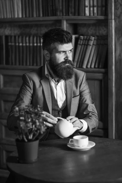 Ritratto di uomo barbuto che beve tè nella biblioteca vintage. — Foto Stock