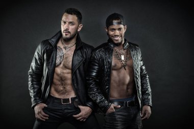 Ceplerinde elele sakallı adam. Afrika adam geriye dönük şapkası. Deri ceketler yan yana duran iki erkek modeli. Seksi organları, motorcularla şehvet ve baştan çıkarma kavramı