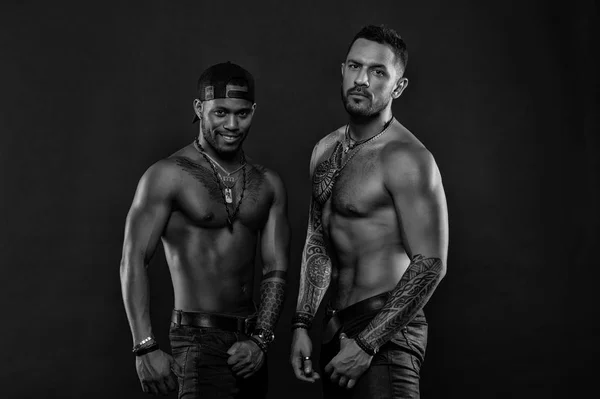 Men with fit tattooed bodies. Fashion models with tattoo in jeans. African and hispanic men with sexy torsos. Sportsmen with muscular chest and belly. Sport with fitness and bodycare, black and white — Stock Photo, Image