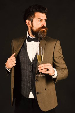 Sakallı adam şampanya bardağı tutuyor..