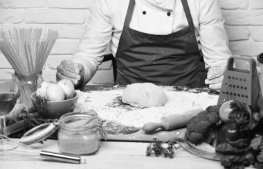 Yemek pişirme süreci konsepti. Erkek eller yoğurulmuş hamur ile çalışır.