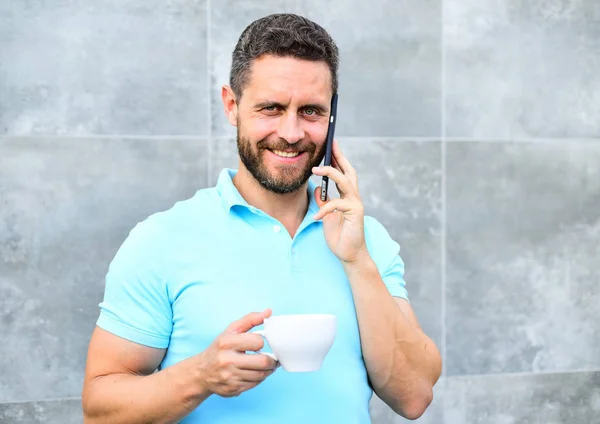 Homme boire cappuccino parler téléphone gris fond de mur. Pourquoi les entrepreneurs boivent du café. Même si vous buvez du café en déplacement, chaque gorgée est une petite pause dans votre journée et un petit moment d'autosoin. — Photo