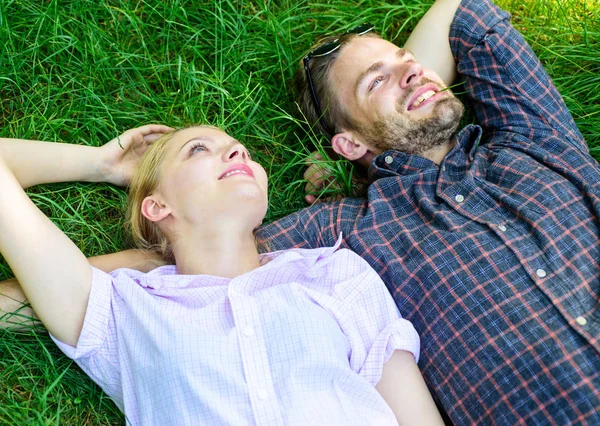 Természet tölti ki őket a frissesség és a béke. Borostás férfi és a lány feküdt, füves réten. A fickó és a lány boldog gondtalan élvezheti a frissesség, a fű. Közelebb a természethez. Pihentető szerelmes pár feküdt rét — Stock Fotó