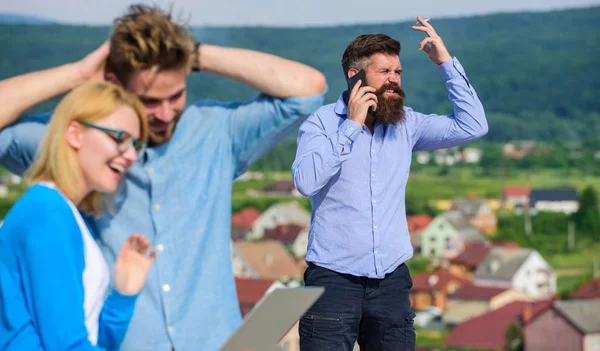 Pareja divirtiéndose mientras Internet navegar al aire libre. Un par de colegas coqueteando mientras jefe ocupado con la conversación móvil. Beneficios de Internet móvil. Colegas utilizan videoconferencia en su lugar llamada móvil —  Fotos de Stock