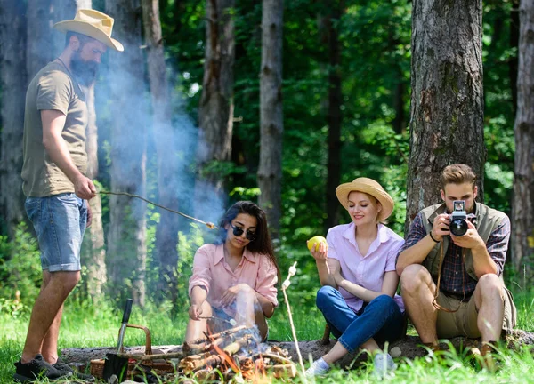 Zelten und Wandern. Firmenwanderer entspannen bei Picknick im Waldhintergrund. verbringen Sie viel Zeit am Wochenende. Machen Sie eine Pause, um etwas zu essen. Firmenfreunde entspannen sich und picknicken in der Natur — Stockfoto