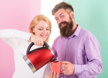 Kupa ve elektrikli çaydanlık sabah kahve içmek hazır kadınla olan adam. İlk iş her sabah sıcak içecek hazırlamak. Enerji ücret favori sıcak bir içecek al. Sabah kahve keyfi