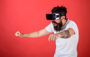Vr sakallı sürüş motosiklet, kırmızı arka plan gözlük. Sanal gerçeklik yüksek hızda sürüş bisiklet şok yüzündeki hippi. Sanal yarış kavramı. Adam oyun Vr içinde yarış oyunu