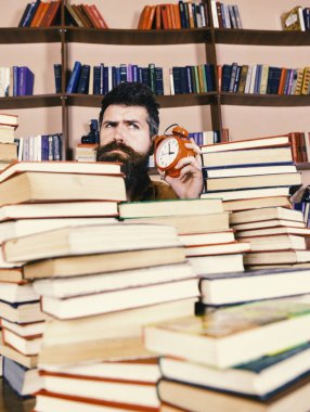 Zaman stop kavramı. Öğretmen ya da sakal Kitaplığı'nda eğitim ile öğrenci. Adam, çalar saat ile kitap yığınları dışarı bakmak bilim adamı. Düşünceli yüz dinleme erkek saat, arka plan üzerinde kitap rafı