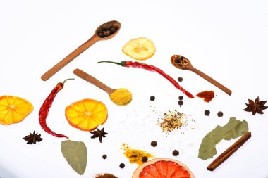 Mutfak sanat kavramı. Kaşık mutfak otlar, Yıldız anason ve beyaz zemin üzerine defne yaprağı ile. Baharat ve kuru malzemeyi kaşıklarla bileşimi. Mutfak otlar ve baharatlar ile dolu kaşık