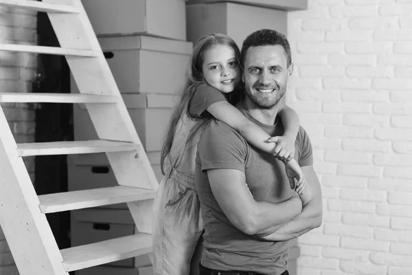 Hija y padre cerca de escalera y pila de cajas — Foto de Stock