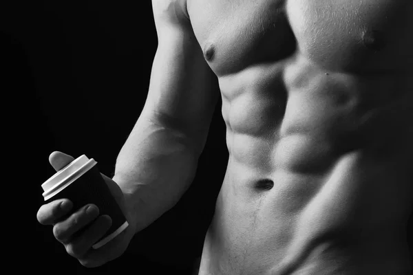 Athletes body in close up, hand holding coffee cup — Stock Photo, Image