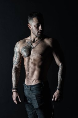 Güçlü gövde sakallı adam. Dövmeli kol ve göğüs olan adam. Seksi göbek ile dövme modeli. Sporcu ya da atlet moda kot pantolon. Fitness ve spor vintage filtre ile ilgilenmek