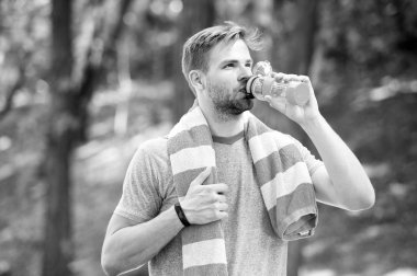 Adam atletik görünümlü şişe su ile tutar. Spor ve sağlıklı yaşam konsepti. Sporcu eğitim Stadyumu'nda güneşli bir gün sonra su iç. Adam atlet sportif giysiler açık eğitim